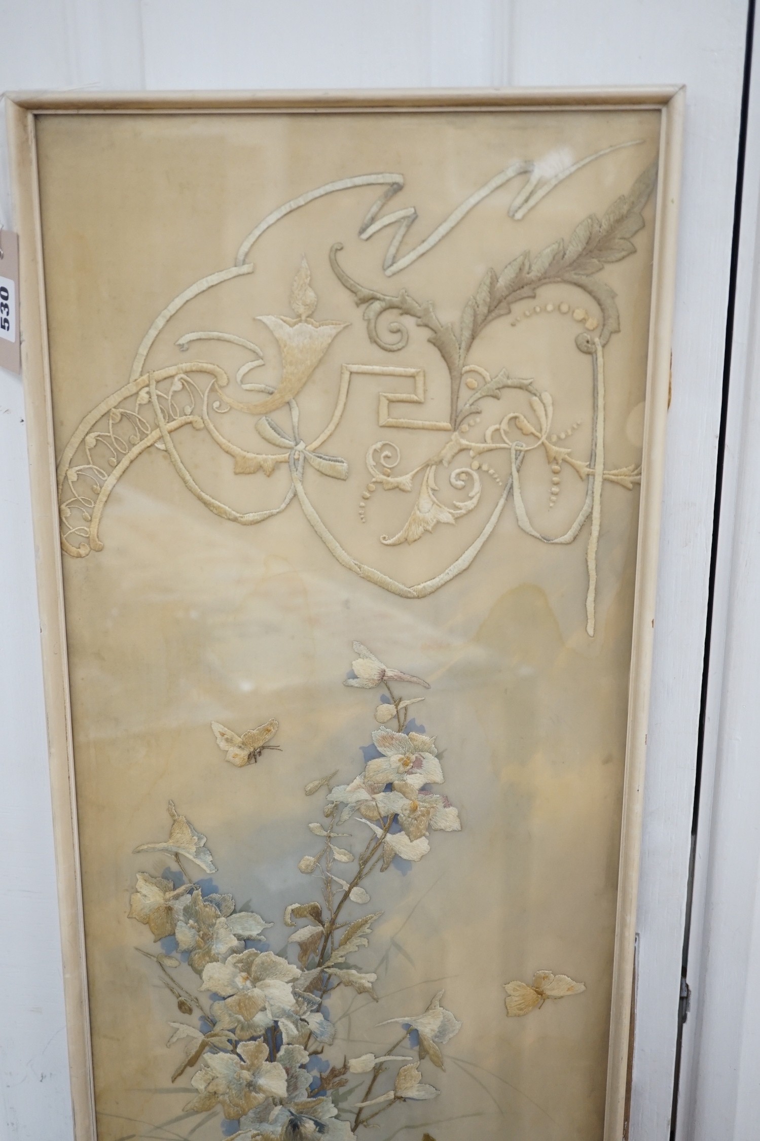 A framed silk embroidered panel, possibly French, cut from a larger piece, 137cms high x 27wide